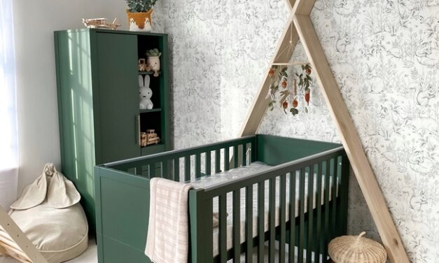 Un dormitorio de bebé con cuna verde